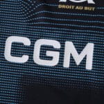 Close-up of Olympique Marseille Away 2025/26 Fan Version jersey showing "CGM" sponsor and part of club motto.