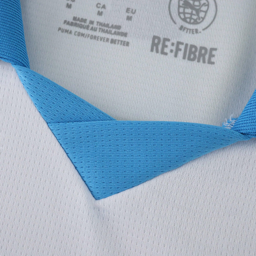 Close-up of Olympique Marseille 2025/26 home fan jersey collar with light blue and white fabric details.