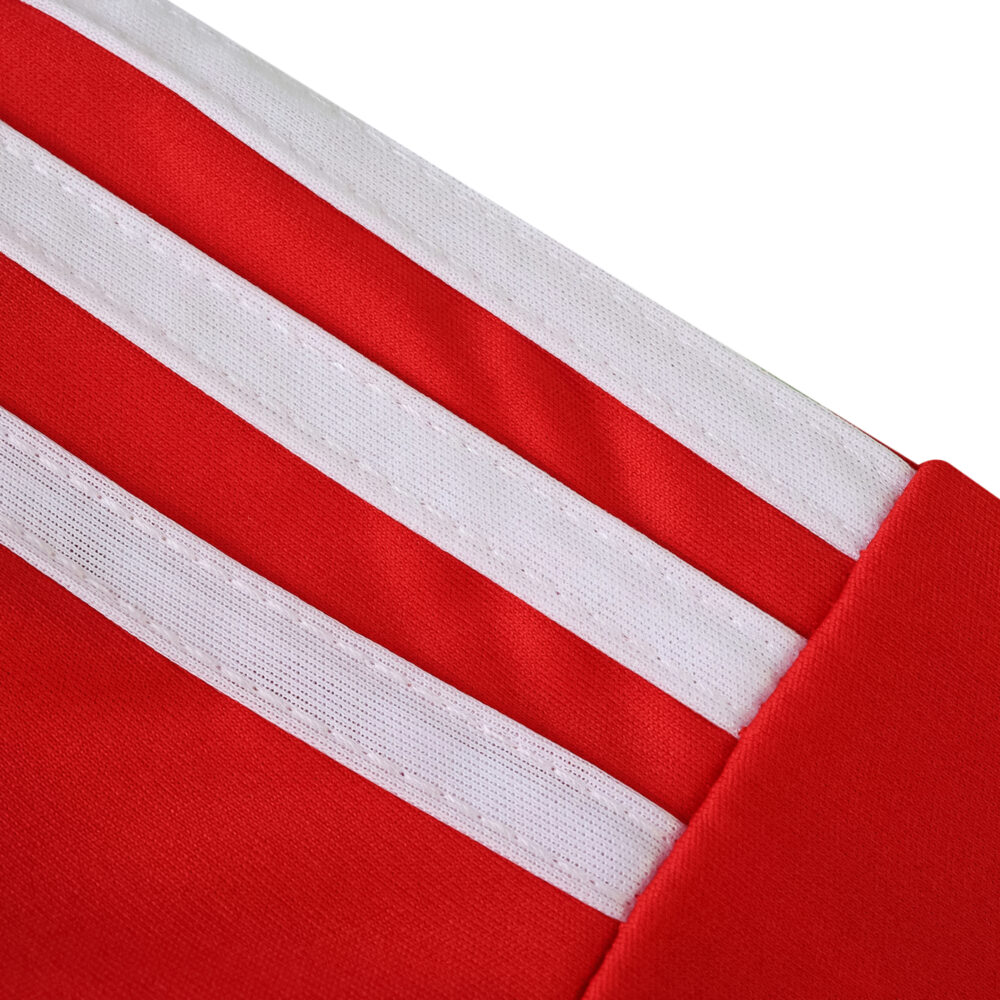 Close-up of the Union Berlin Home 2025/26 Fan Version jersey showing red fabric with three white stripes.