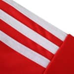 Close-up of the Union Berlin Home 2025/26 Fan Version jersey showing red fabric with three white stripes.