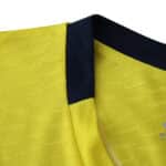 Close-up of Villarreal 2025/26 home jersey collar, featuring yellow fabric with a navy trim.
