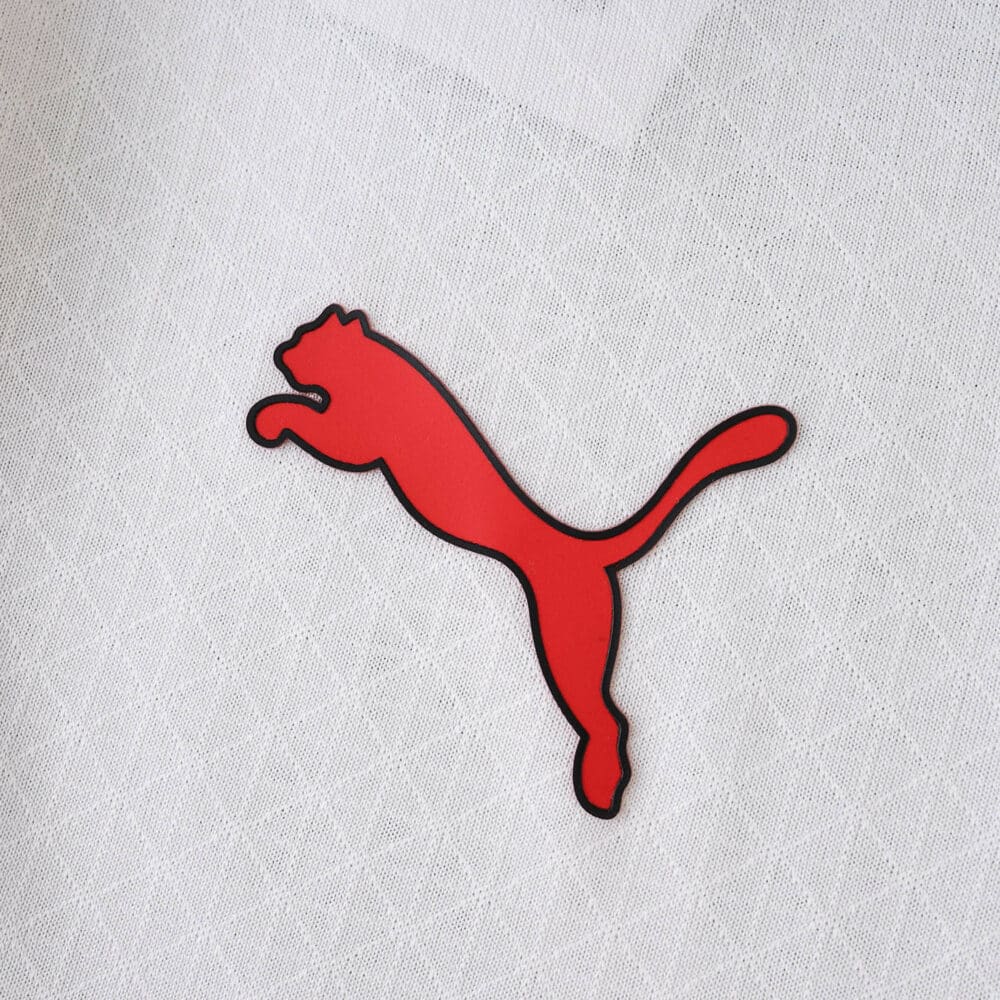 Red Puma logo on white AC Milan Away 2025/26 Player Version jersey fabric background.