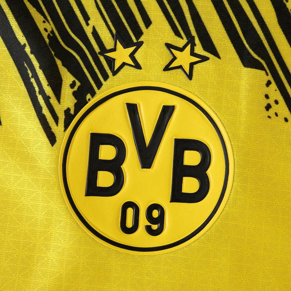 Close-up of Borussia Dortmund 2025/26 Home Player Version jersey crest with two stars.