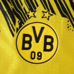 Close-up of Borussia Dortmund 2025/26 Home Player Version jersey crest with two stars.