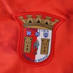 Sporting Clube de Braga crest on the 2025/26 home fan jersey, embroidered on red fabric.