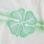 Embroidered green and white four-leaf clover crest on the Celtic Third 2025/26 Fan Version jersey.