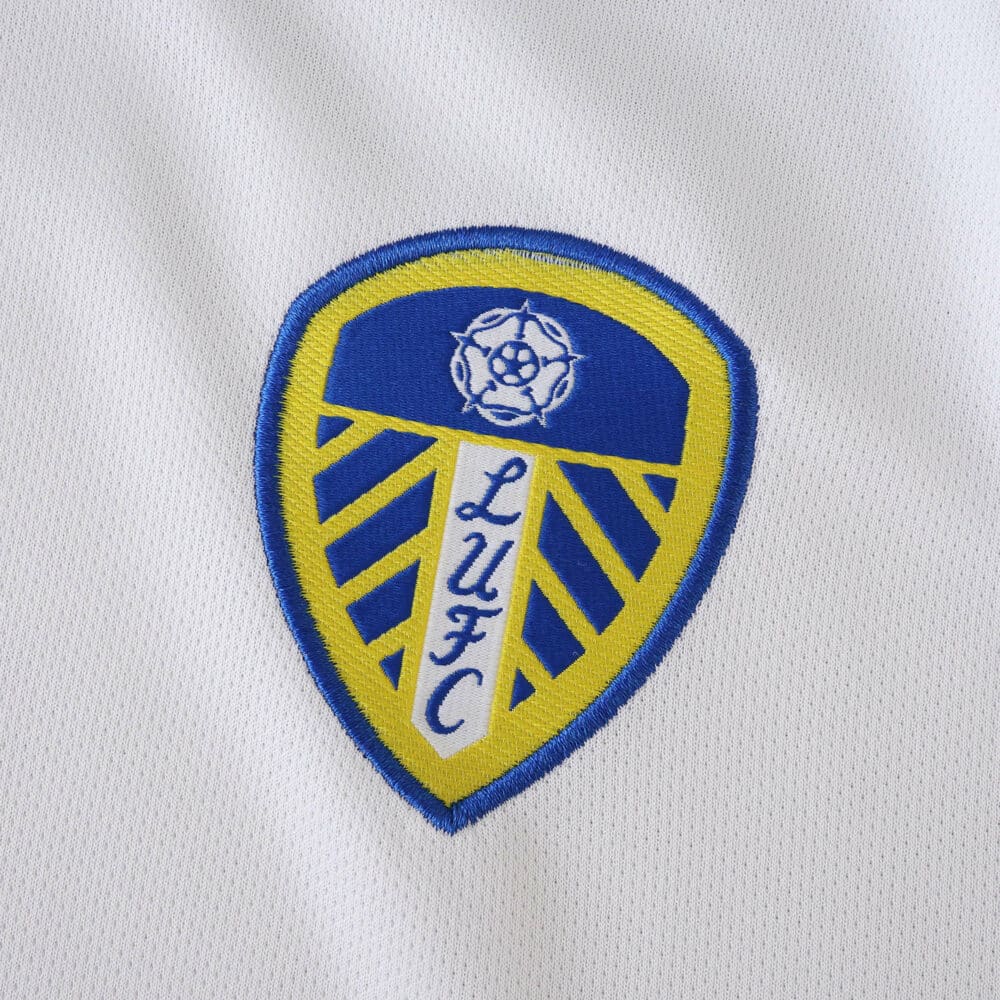 Leeds United badge detail on the 2025/26 home fan version jersey fabric.