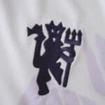 Close-up of the Manchester United crest on the 2025/26 away fan version jersey fabric.