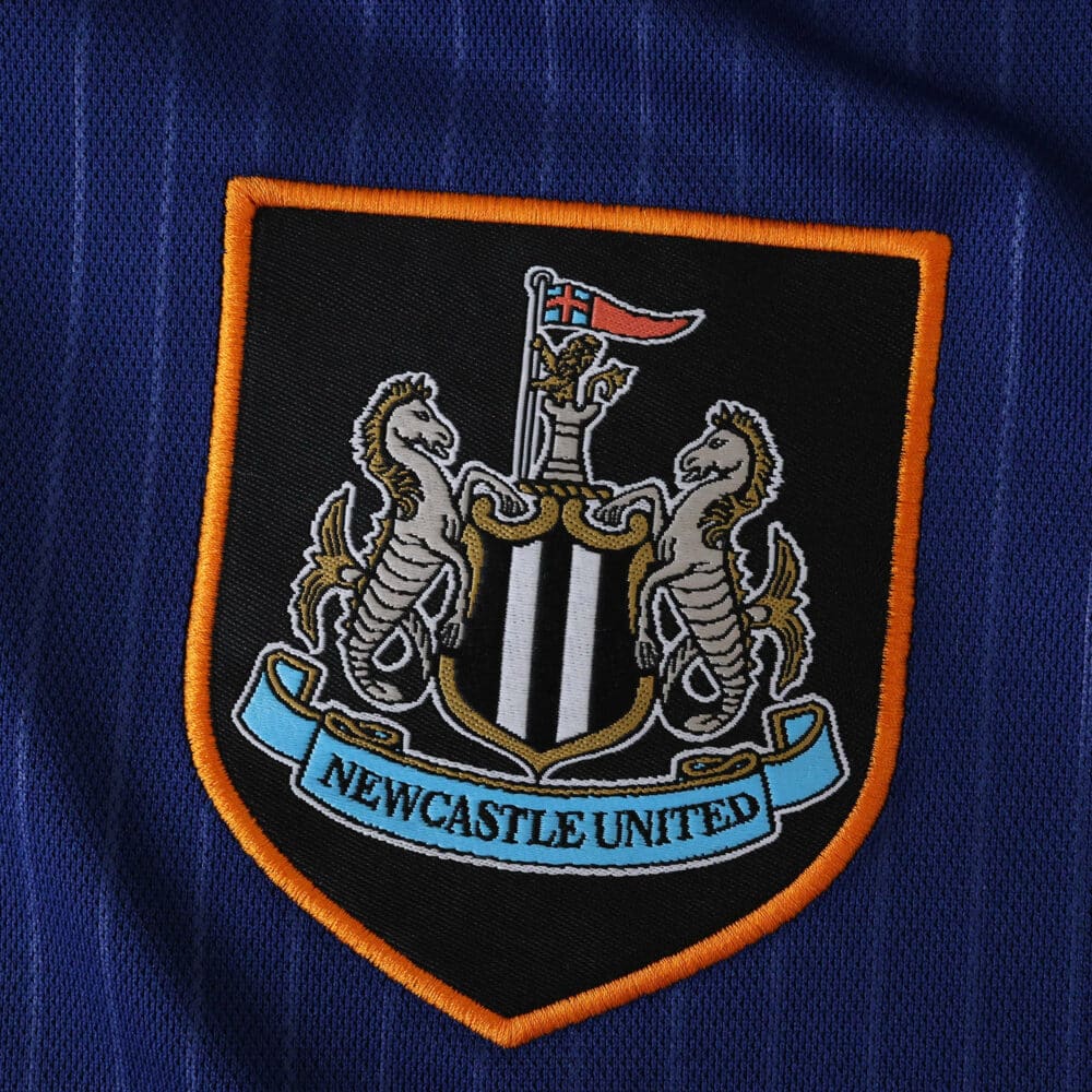 Newcastle United crest on the 2025/26 third fan version jersey, featuring seahorses and black-white stripes.