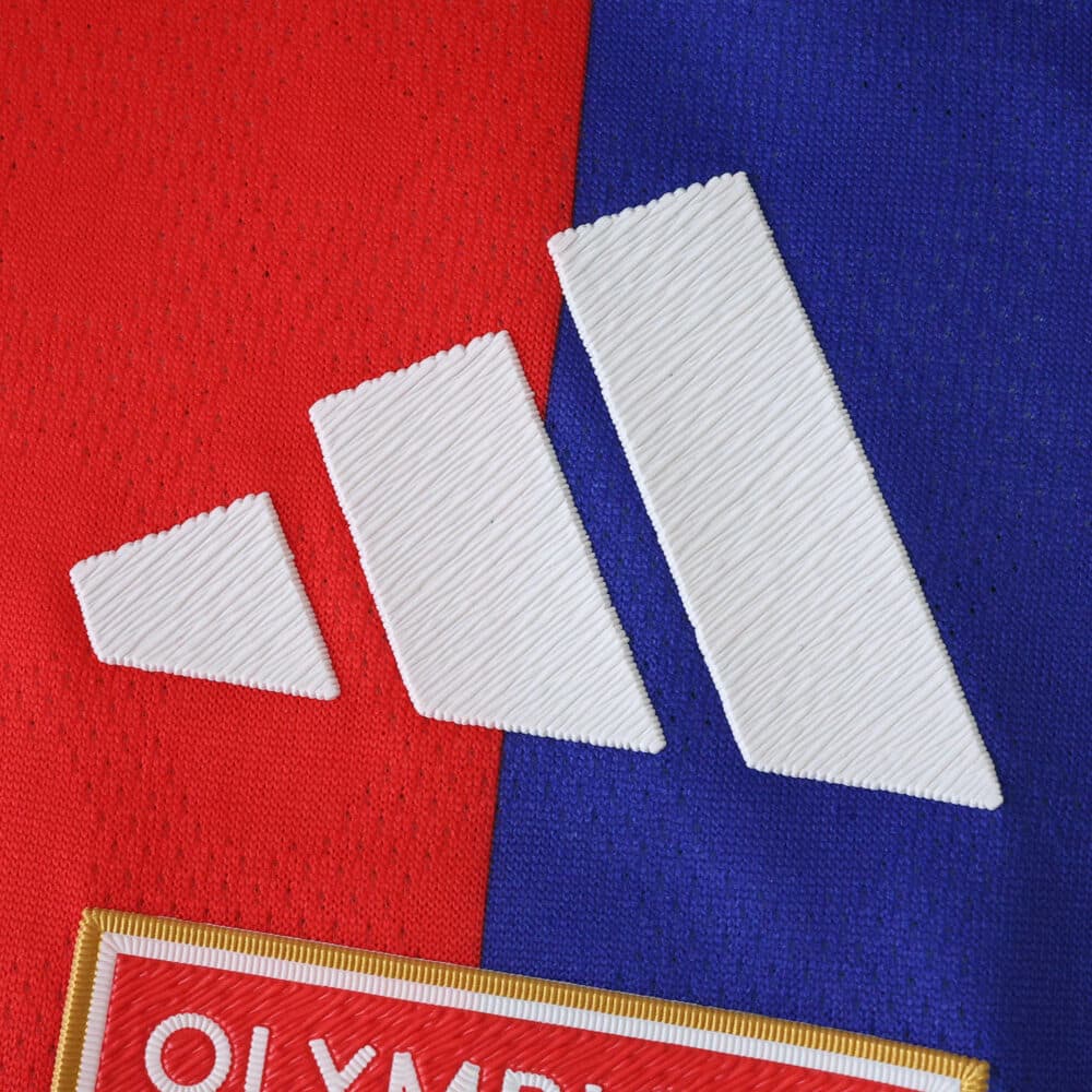 Close-up of the Adidas logo on the Olympique Lyonnais 2025/26 Home Player Version jersey.