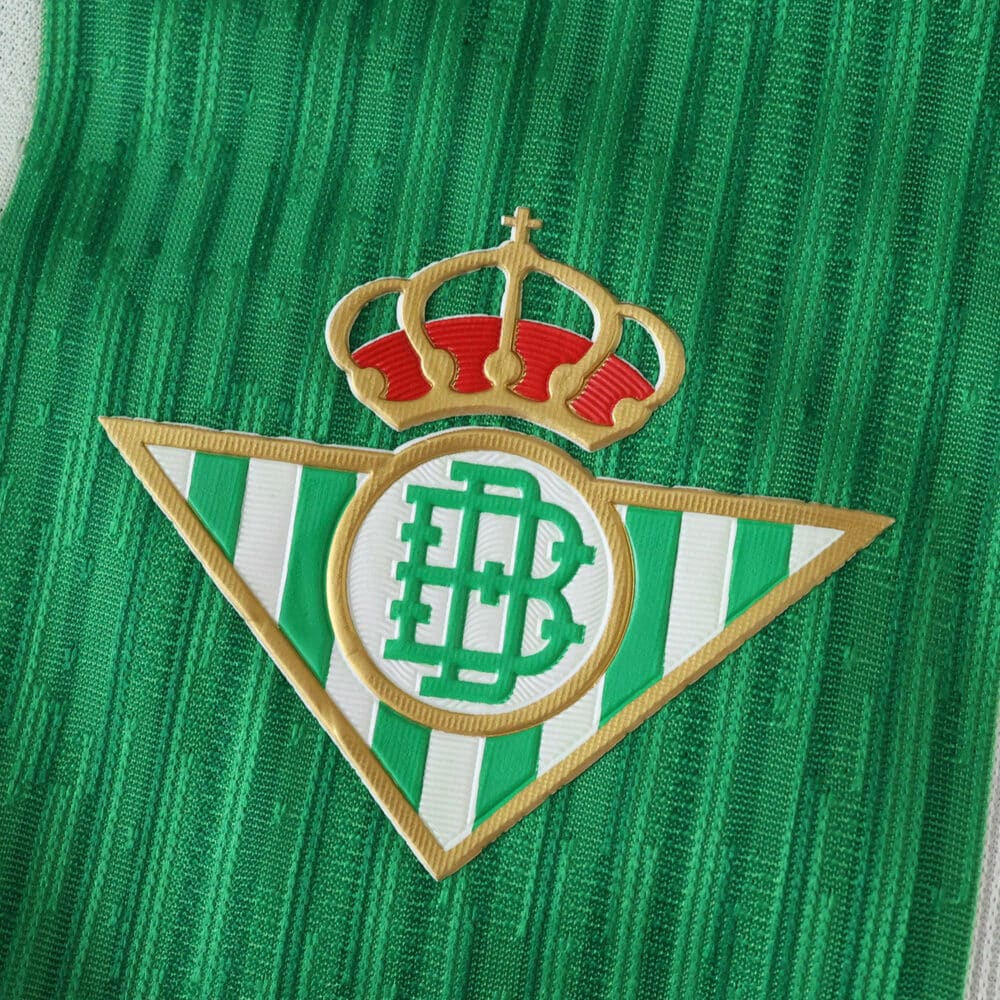 Real Betis 2025/26 Home Player Version jersey badge on green striped fabric.