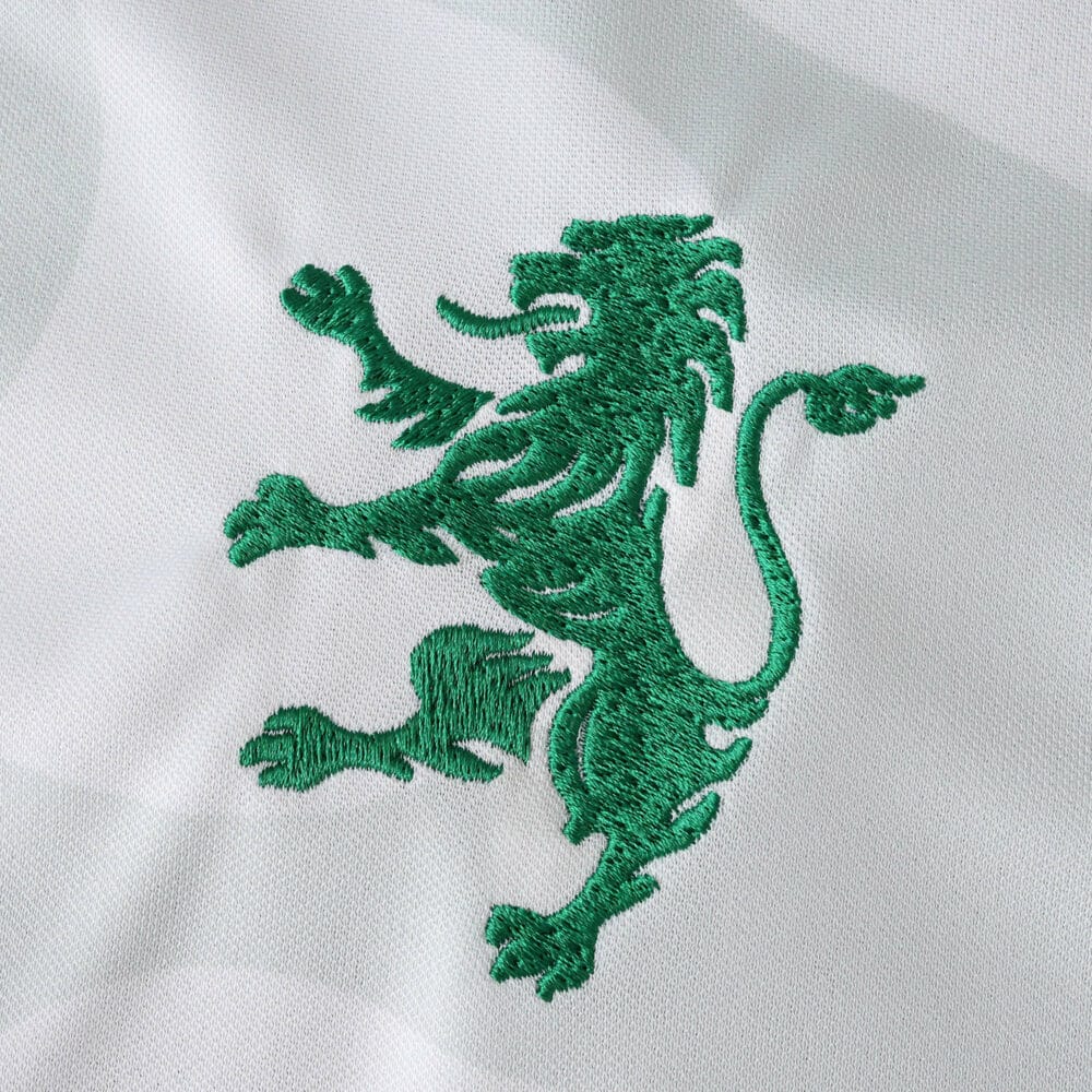 Green lion emblem embroidered on white Sporting CP Away 2025/26 Fan Version jersey fabric.