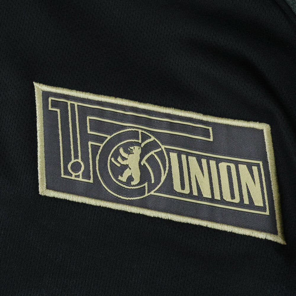 Close-up of the Union Berlin club crest on the 2025/26 away fan version jersey.