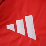 Close-up of the white Adidas logo on the red Aberdeen Home 2025/26 Fan Version jersey.