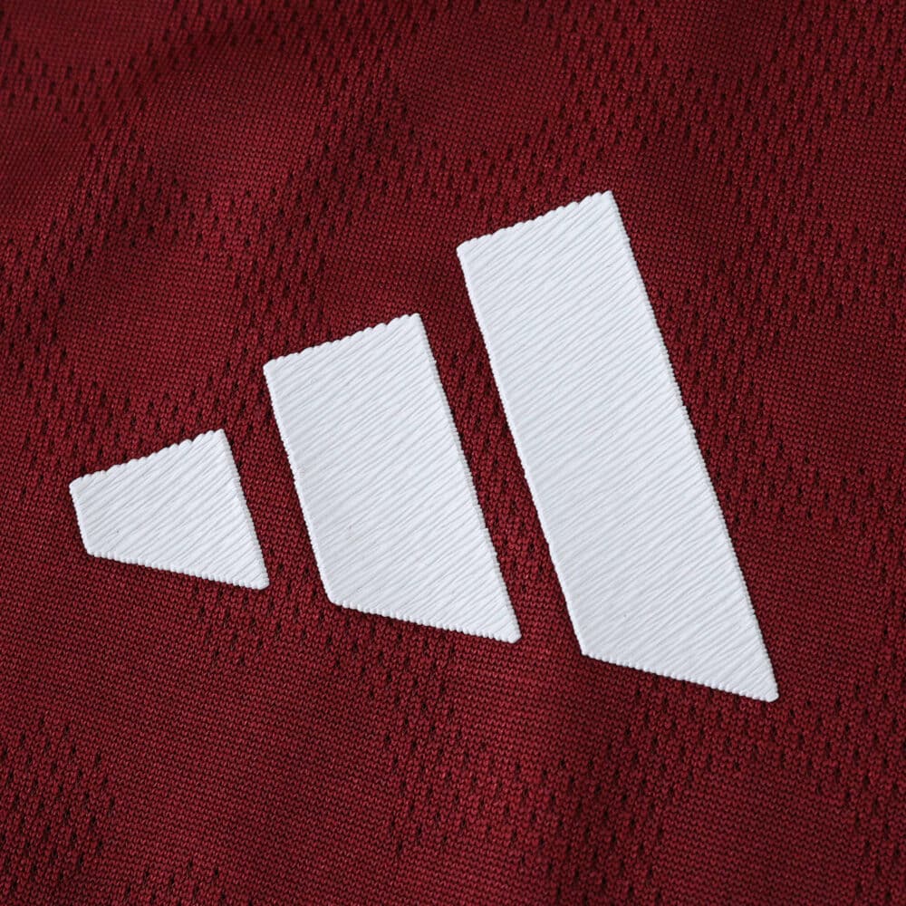 Close-up of the Aston Villa 2025/26 home player version jersey showing a white Adidas logo on claret fabric.