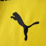 Black Puma logo on yellow Borussia Dortmund 2025/26 Home Player Version jersey fabric.