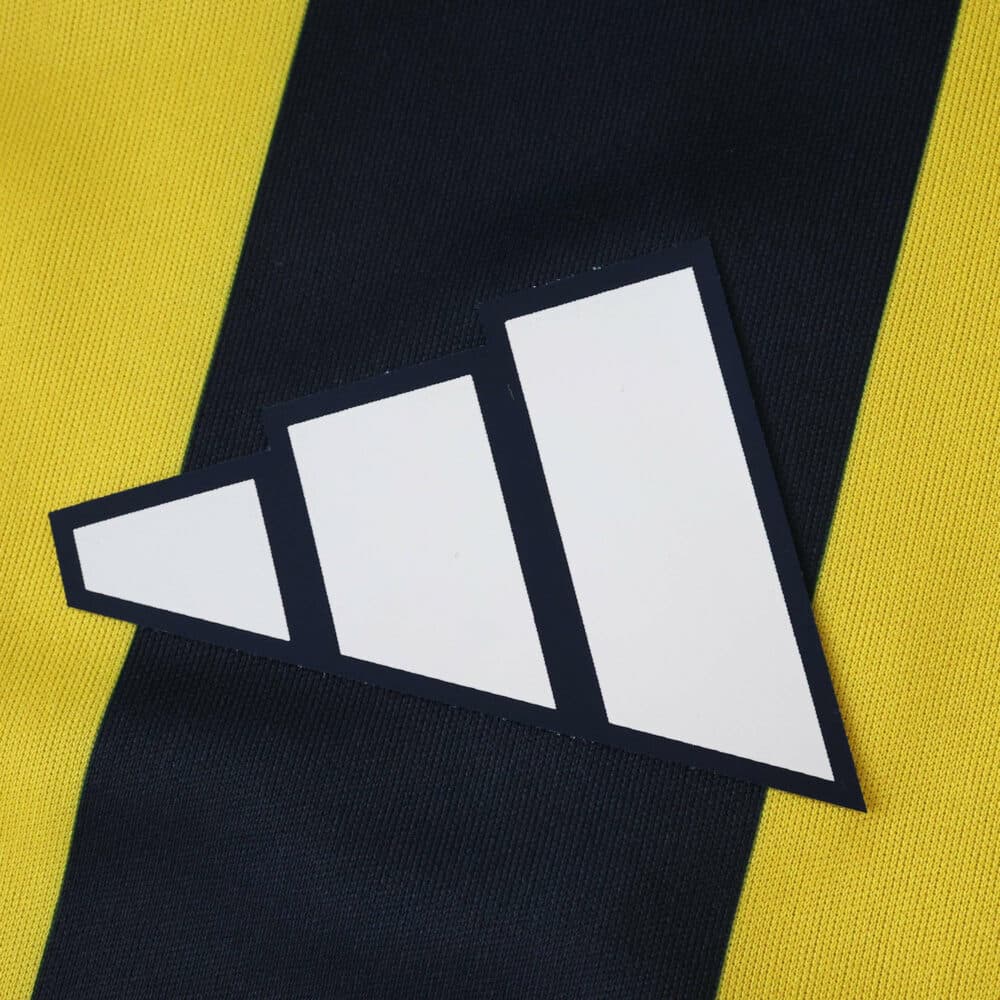 Close-up of the Adidas logo on the Fenerbahce 2025/26 Home Fan Version jersey with yellow and navy stripes.