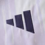 Close-up of the Adidas logo on the 2025/26 Manchester United away fan version jersey.