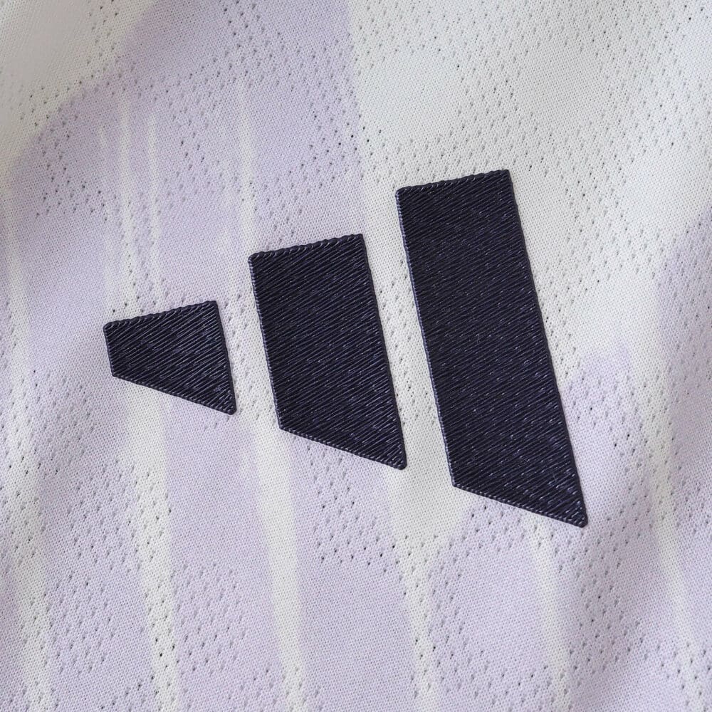 Close-up of the Adidas logo on the Manchester United 2025/26 away player version jersey.