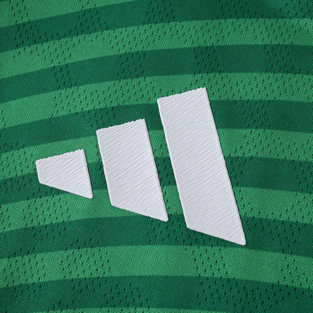 Close-up of Newcastle United 2025/26 away player version jersey with green stripes and white logo.