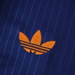 Close-up of the orange Adidas Trefoil logo on the Newcastle United 2025/26 Third Fan Version shirt.