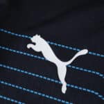Close-up of Puma logo on the Olympique Marseille 2025/26 away player jersey with blue stripes.