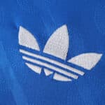 Close-up of the white Adidas Trefoil logo embroidered on the blue Real Madrid Third 2025/26 Fan Version jersey.