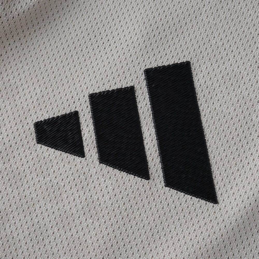 Close-up of the Adidas logo on the SL Benfica Away 2025/26 Player Version jersey fabric.