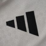 Close-up of the Adidas logo on the SL Benfica Away 2025/26 Player Version jersey fabric.