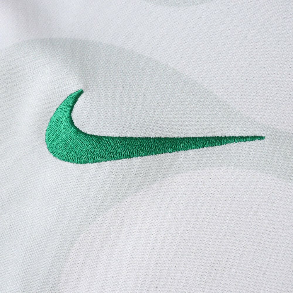 Close-up of green Nike logo embroidered on the Sporting CP Away 2025/26 Fan Version jersey.