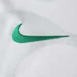 Close-up of green Nike logo embroidered on the Sporting CP Away 2025/26 Fan Version jersey.