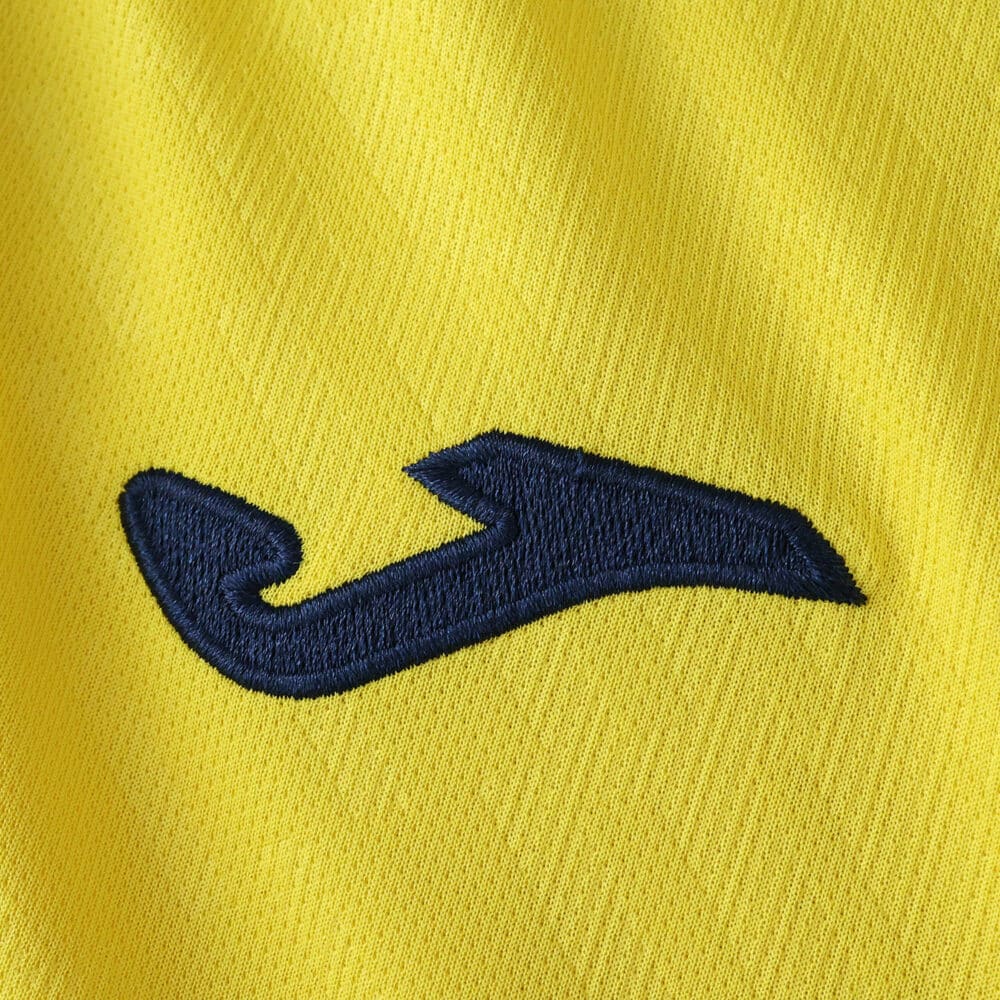 Close-up of the Villarreal 2025/26 home fan jersey showing the blue Joma logo on yellow fabric.
