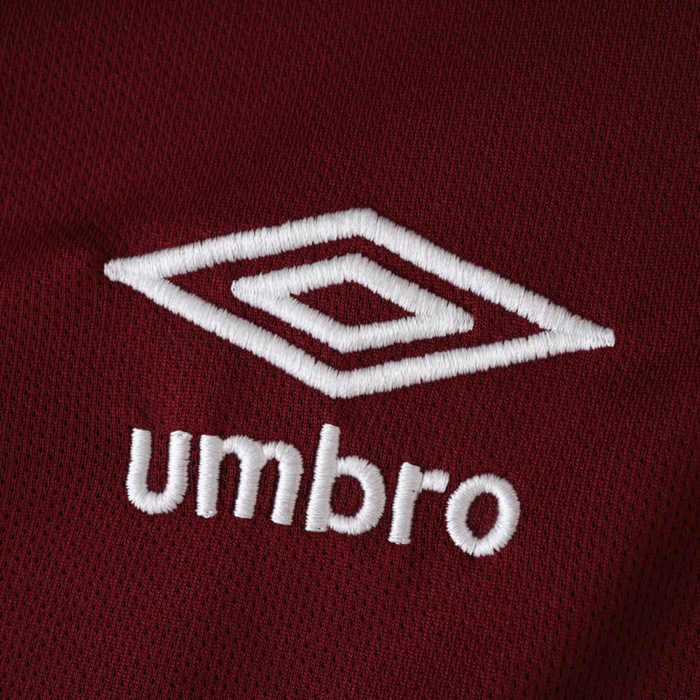 Close-up of the white Umbro logo on the maroon West Ham United 2025/26 Home Fan Version jersey fabric.