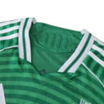 Close-up of Newcastle United 2025/26 away player version jersey collar in green with white stripes.