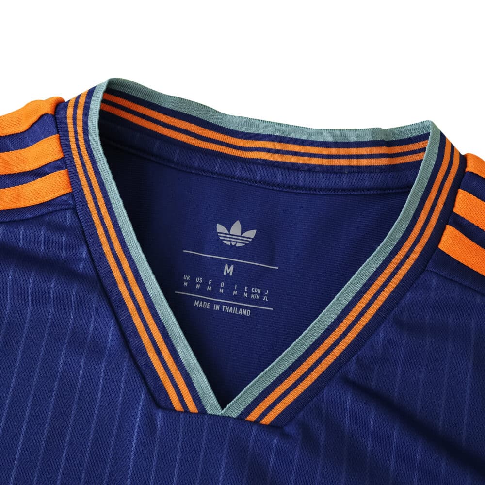 Close-up of Newcastle United Third 2025/26 Fan Version collar with orange and teal striped details.