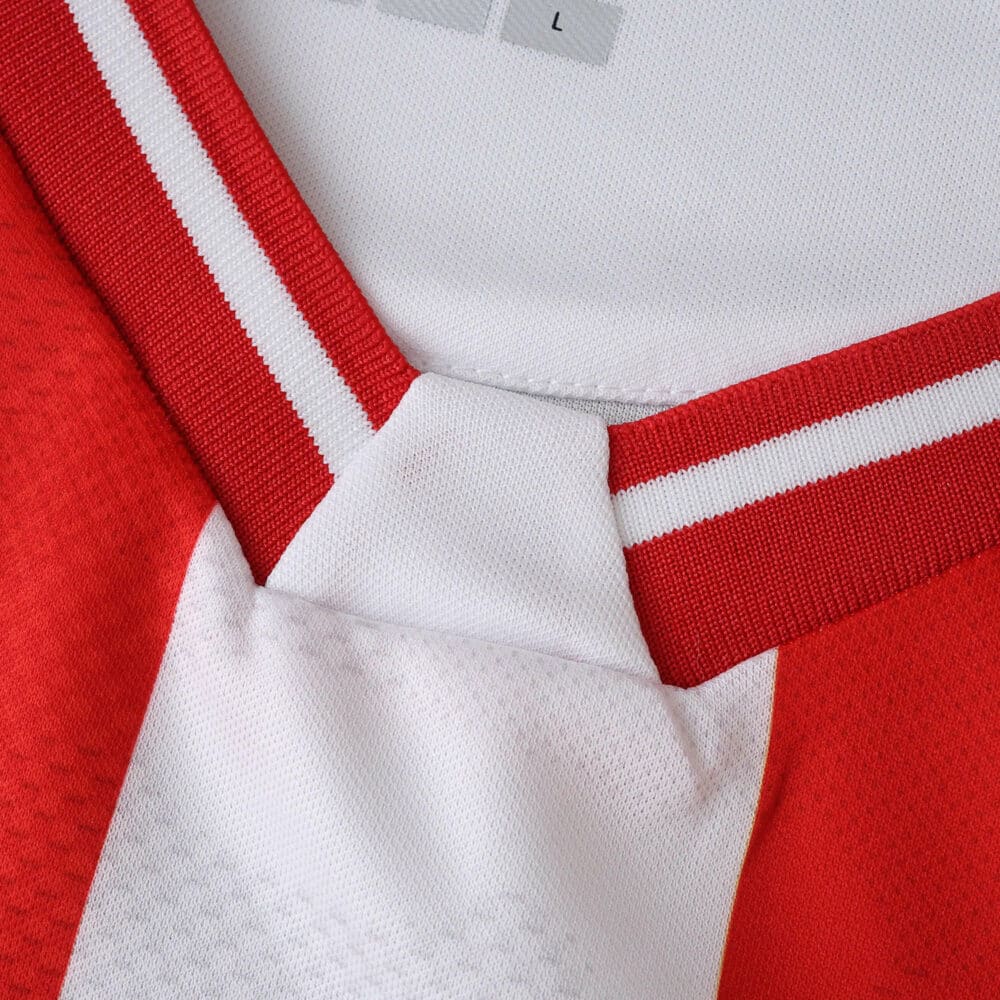 Close-up of FC Köln 2025/26 home fan jersey collar, showing red and white stripe details.