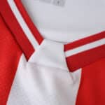 Close-up of FC Köln 2025/26 home fan jersey collar, showing red and white stripe details.
