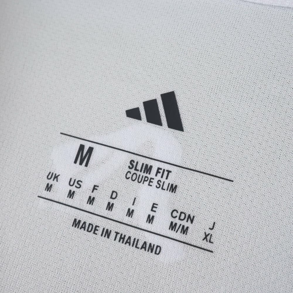 Close-up of the Leeds United 2025/26 home fan jersey inner neck label showing size and fit details.