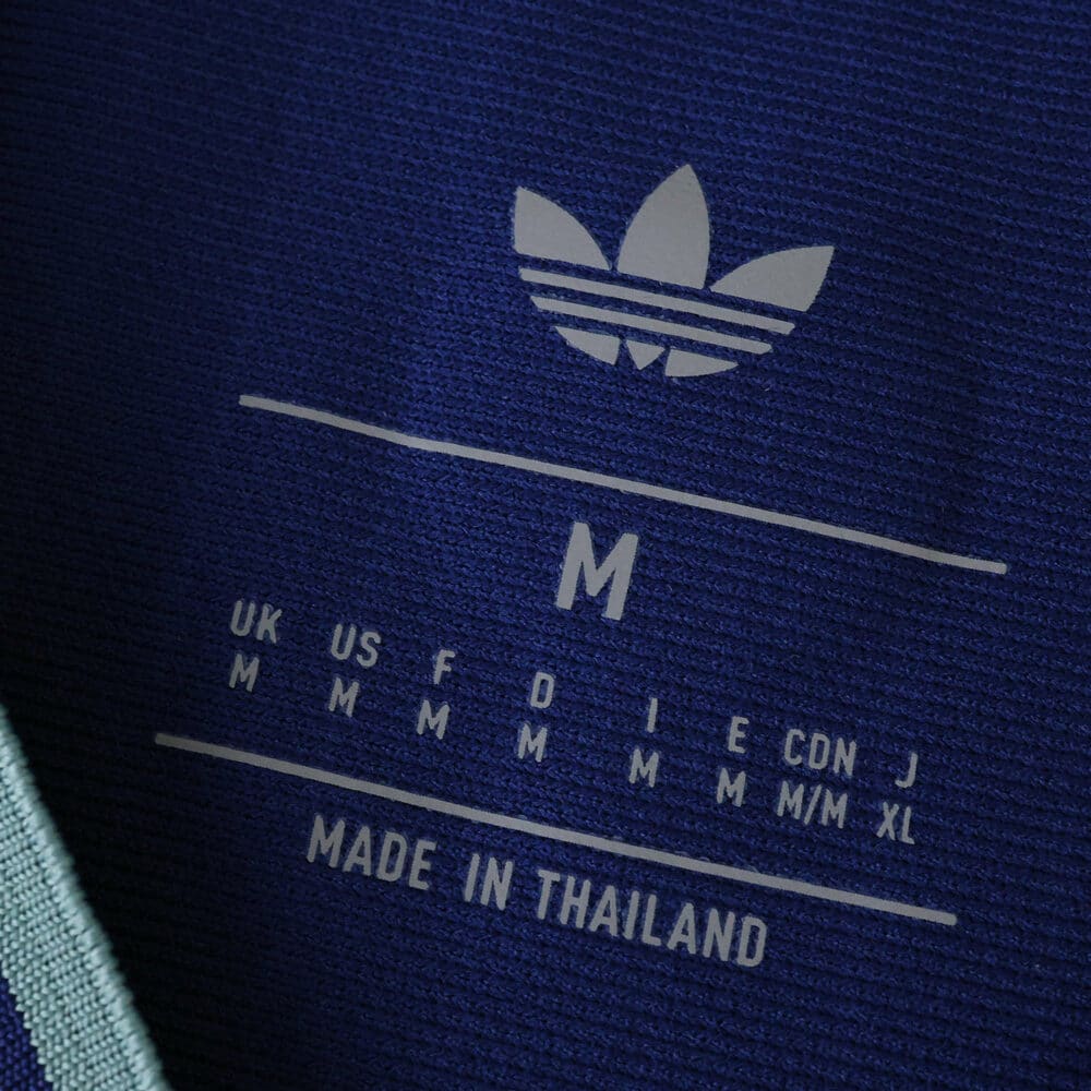 Close-up of Newcastle United Third 2025/26 Fan Version shirt label showing Adidas logo and size details.