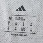 Close-up of the inner tag showing Adidas logo, size M, slim fit info, and 'Made in Thailand' text.