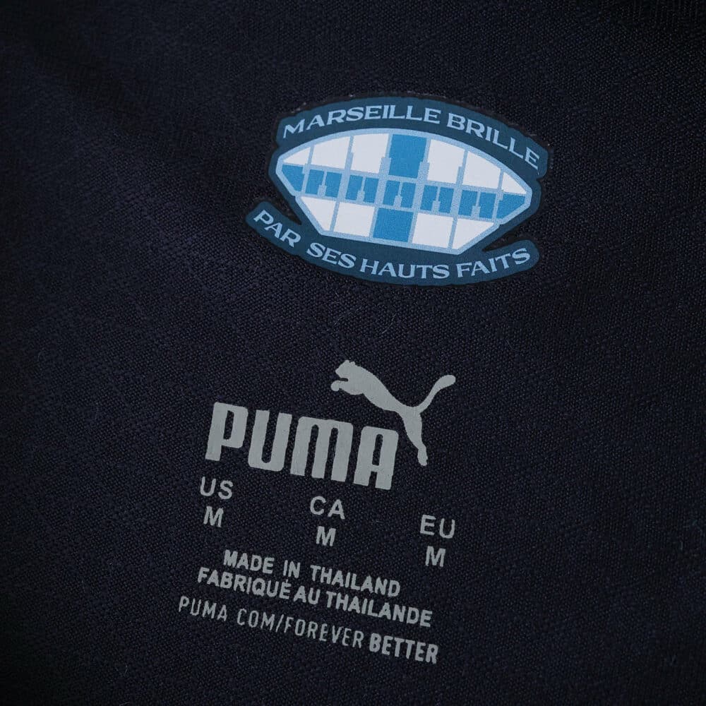 Close-up of Olympique Marseille Away 2025/26 Player Version jersey label with club crest and Puma logo.