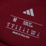 Close-up of Roma Home 2025/26 Fan Version shirt label showing size M, slim fit, made in Thailand.
