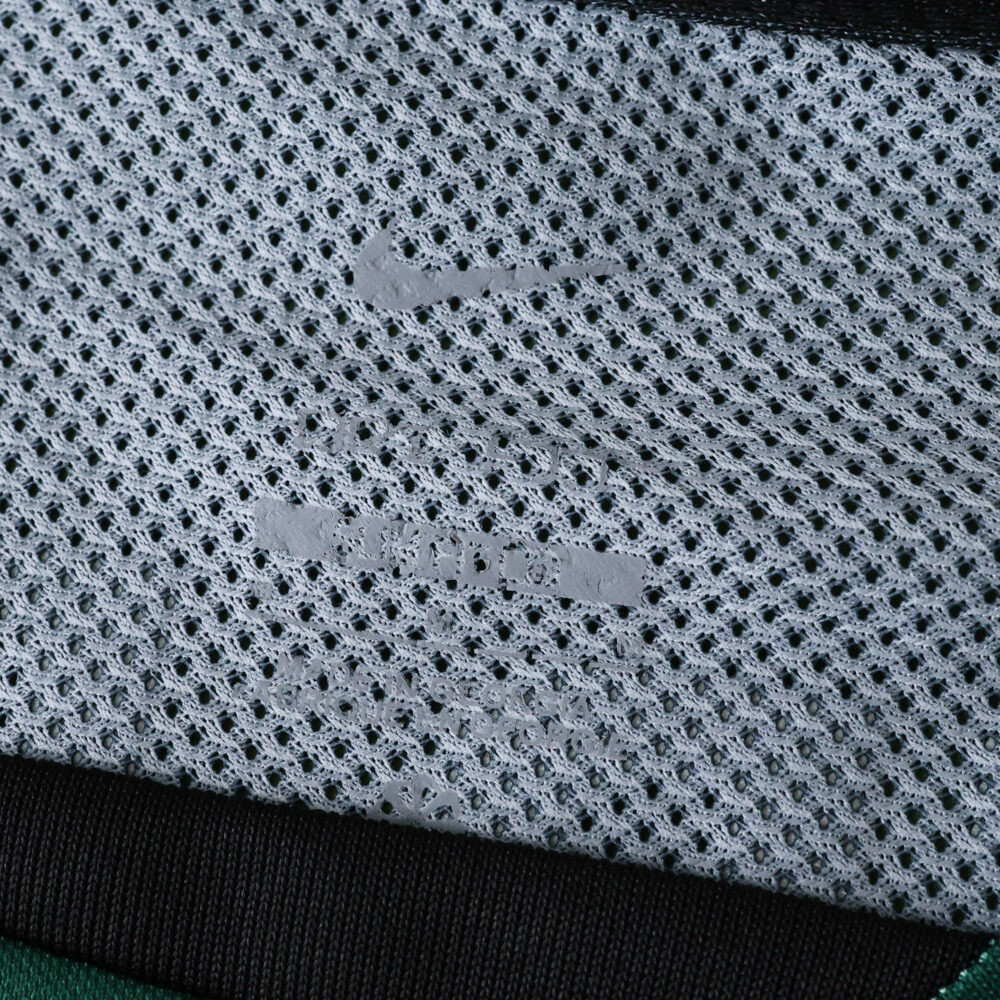 Close-up of Sporting CP Third 2025/26 Fan Version jersey tag showing Nike logo and size details on mesh fabric.