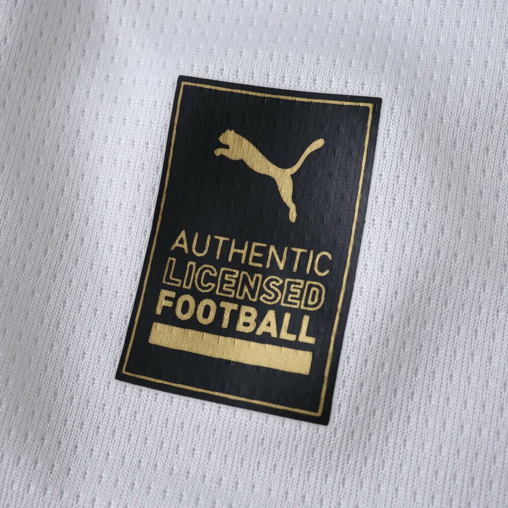 Close-up of the gold Puma Authentic Licensed Football badge on the Parma Home 2025/26 Fan Version jersey.