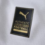 Close-up of the gold Puma Authentic Licensed Football badge on the Parma Home 2025/26 Fan Version jersey.