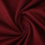 Close-up of Aston Villa 2025/26 Home Player Version jersey fabric in deep claret red with textured pattern.