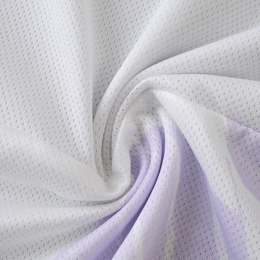 Close-up of Manchester United 2025/26 away player jersey fabric showing white and light purple mesh texture.