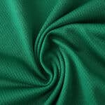 Close-up of green Newcastle United Away 2025/26 Player Version jersey fabric texture.
