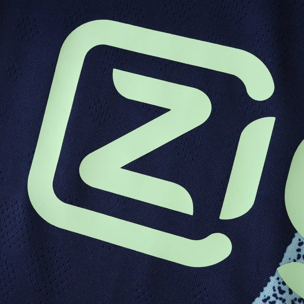 Close-up of the Ajax Away 2025/26 Player Version jersey featuring a neon sponsor logo on dark fabric.