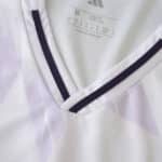 Close-up of the Manchester United 2025/26 away fan jersey collar with purple accents and size label.